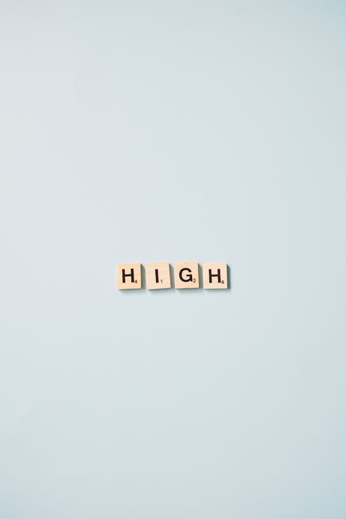 why-choose-us Minimalist art featuring Scrabble tiles spelling 'HIGH' on a light blue background.